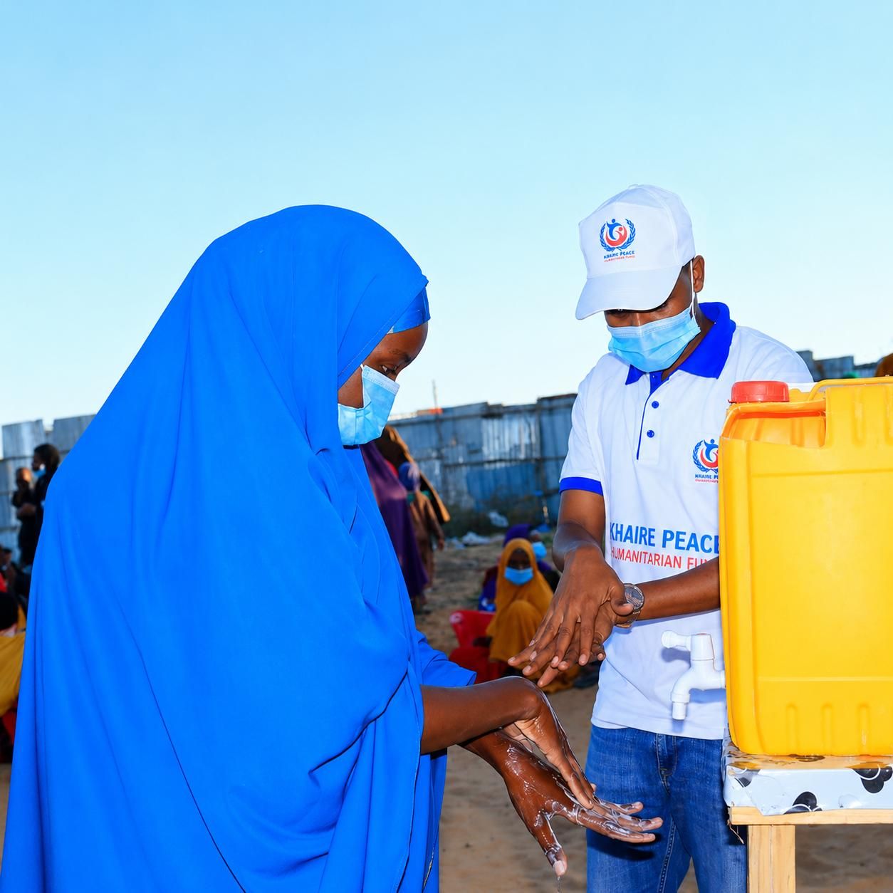 A KPHF hygiene promoter demonstrating handwashing at a water station